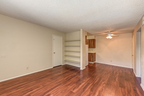 Empty Living Room with Hardwood Inspired Floors, Ceiling Fan/Light and White Door